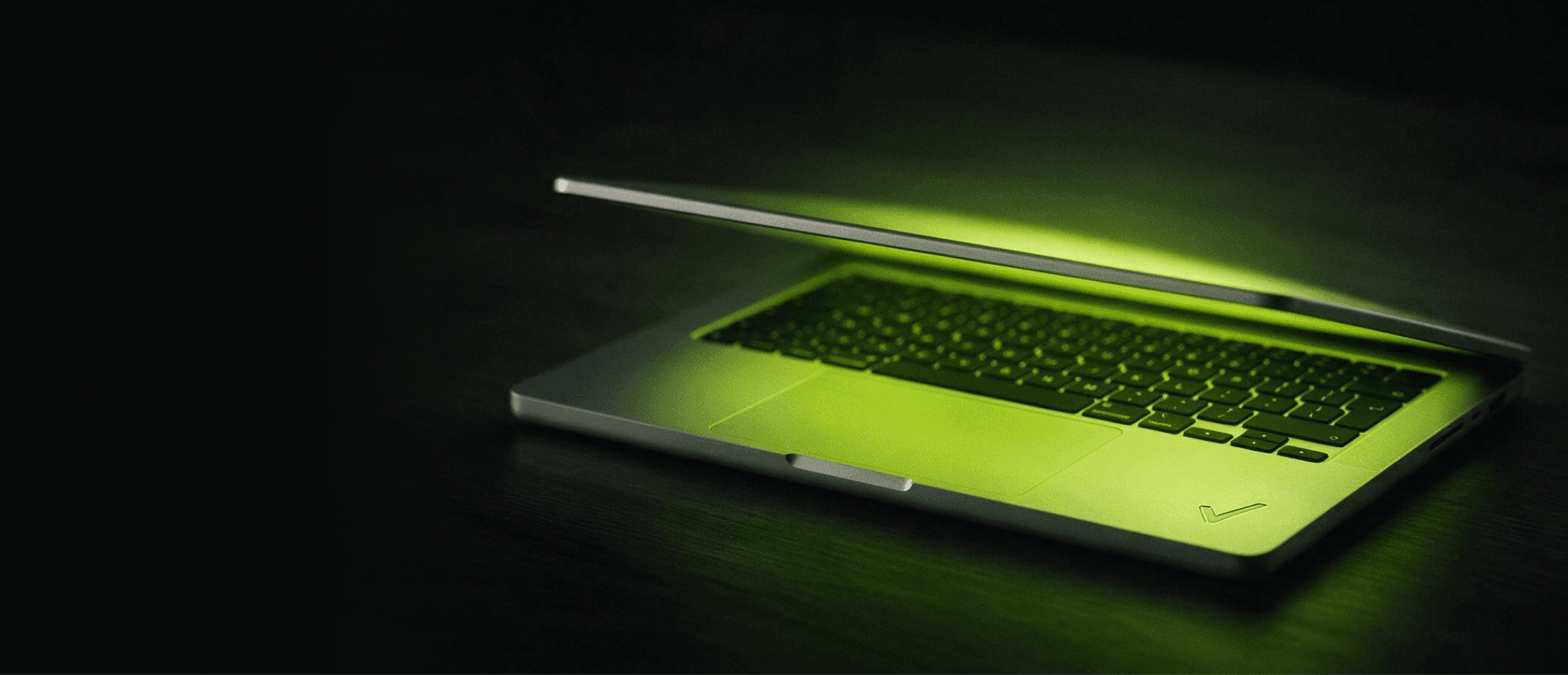 Notebook com brilho verde sobre fundo escuro — a identidade visual da SyForge, na faixa de CTA final.